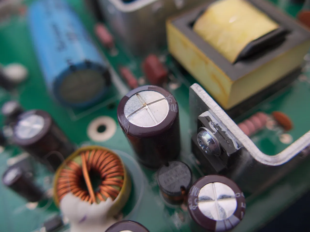 Aufgeblähter Elektrolytkondensator auf der Netzteilplatine eines Monitors
